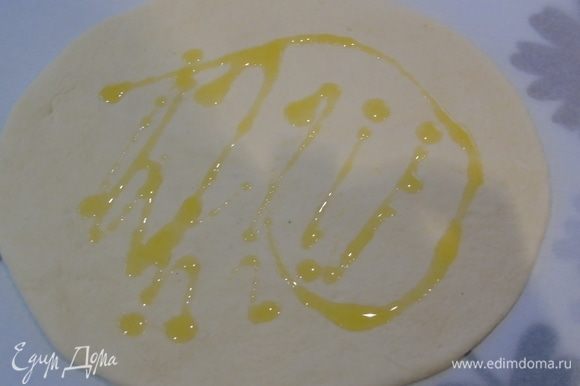 Раскатываем или растягиваем руками тесто, слегка поливаем оливковым маслом.