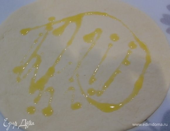 Раскатываем или растягиваем руками тесто, слегка поливаем оливковым маслом.