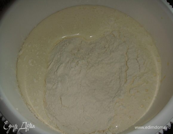 В яичную массу просеять муку с разрыхлителем и перемешать спатулой.
