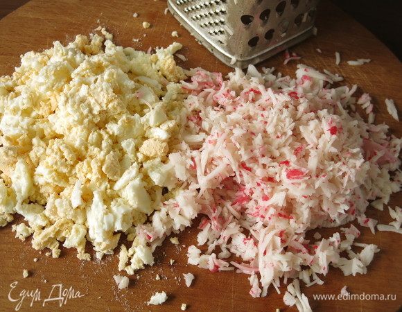 Порубим яйца и измельчим на терке крабовые палочки, мясо очень нежное, волокна легко отделяются.