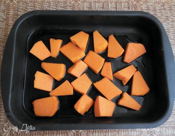 Духовку разогреть до 180°С. Тыкву очистить от кожуры и семян и нарезать на кусочки среднего размера (в списке ингредиентов указан вес уже очищенной тыквы). Нарезанную тыкву выложить в форму для запекания и налить немного воды. Накрыть форму фольгой и запекать до мягкости (30-40 минут). 