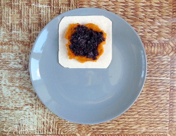 Собирать равиоли нужно на тех тарелках, на которых планируете их подавать. На тарелку выложить 1 квадрат крабово-сливочного желе (более липкой сторойной вверх). Сверху выложить ¼ тыквенного пюре и слегка распределить, не доходя до краев. Затем выложить ¼ карамелизированного лука.