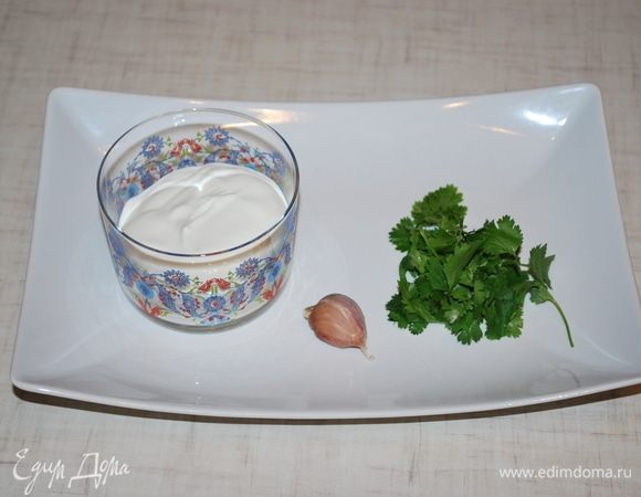 Делаем соус для оладий. Кинзу и чеснок мелко режем.