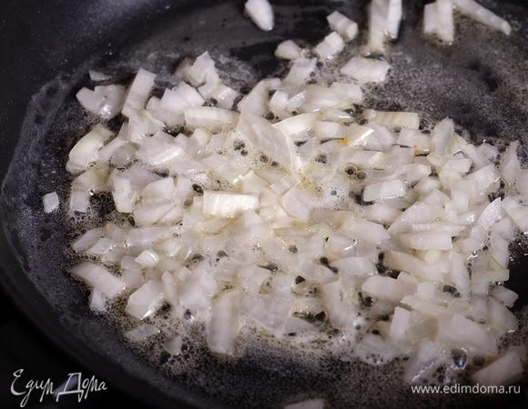 Разделить 25 г сливочного масла пополам, разогреть половину масла в сотейнике и обжарить мелко нарезанный лук до мягкости на среднем огне.