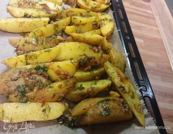 Выложить картофель на противень с пергаментной бумагой и запекать в заранее разогретой до 190°С духовке 20 минут. 