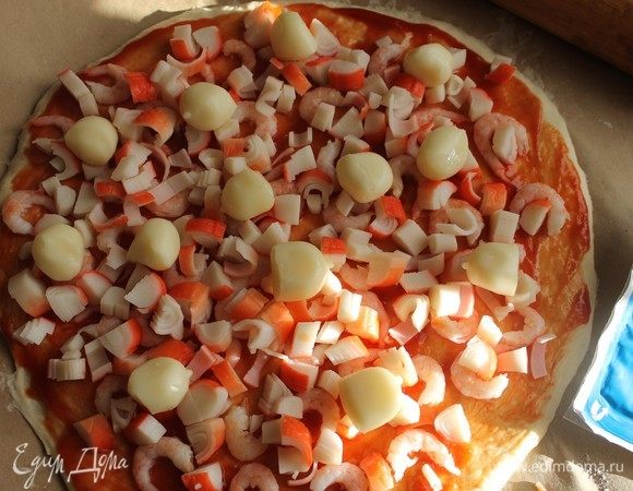 Уложить шарики сыра скаморца и тертый твердый сыр.