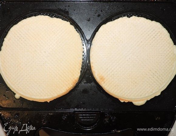 Выпекать вафли в вафельнице и сворачивать в трубочки, пока они горячие.