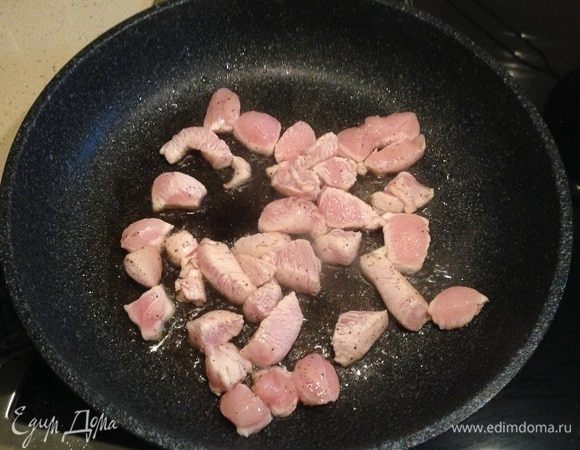 Сковороду сильно разогреть. Налить часть подсолнечного масла, выложить курицу и обжарить пару минут. Затем отложить курицу на тарелку.
