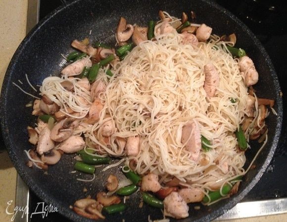 Вернуть в сковороду курицу и выложить лапшу. Перемешать.