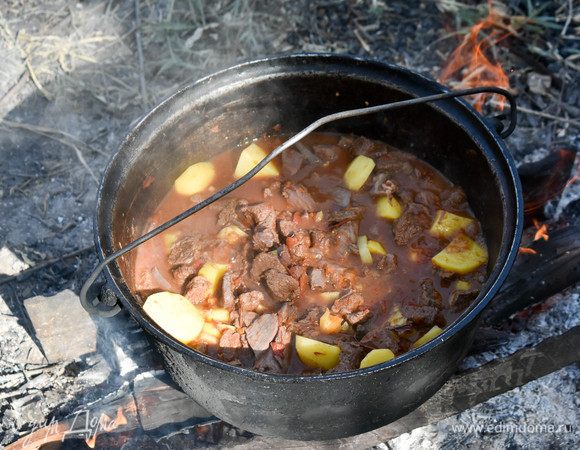 Тушить шулюм еще около часа. Посыпать зеленью и подавать горячим.