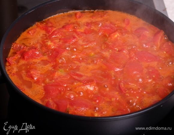 Приготовить томатный соус. Для этого разогреть в сотейнике 1 ст. л. оливкового масла. Нарезать помидоры кубиком, сложить в сотейник и сначала обжарить их на сильном огне минут 7 (пока не дадут много сока), затем тушить на среднем огне минут 10-15. Примерно в середине жарки добавить мелко нарубленный чеснок и несколько ломтиков острого перца чили. В конце добавить соль и сахар — по вкусу. Сахар — примерно 1-2 ч.л., без него не раскроется вкус этого соуса.