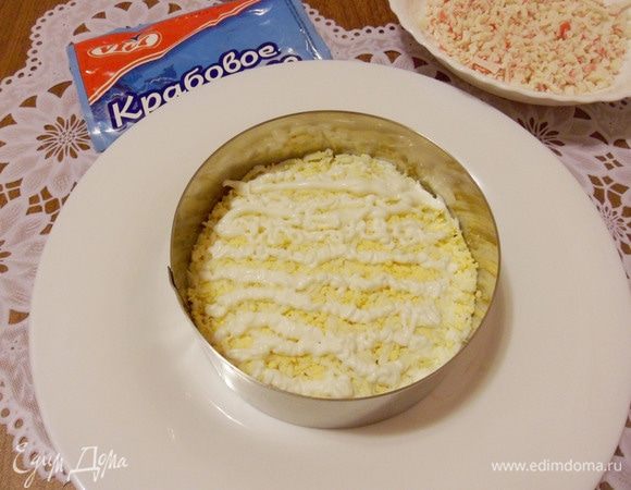 Выложить яйца на слой крабового мяса и нанести сеточку из майонеза.