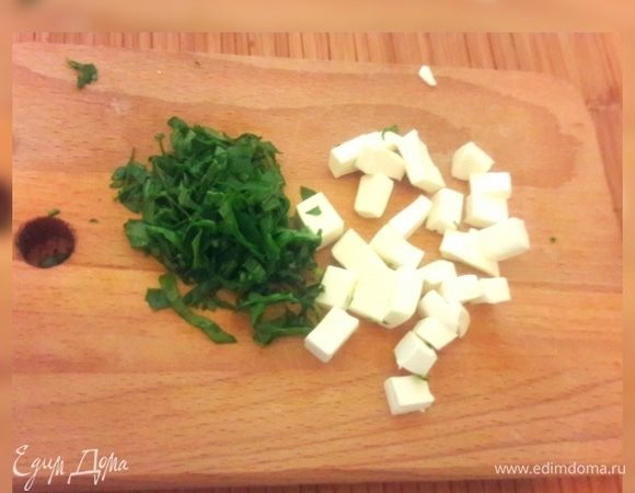 Руколу и сыр фета мелко нарезать и добавить к мучной смеси.