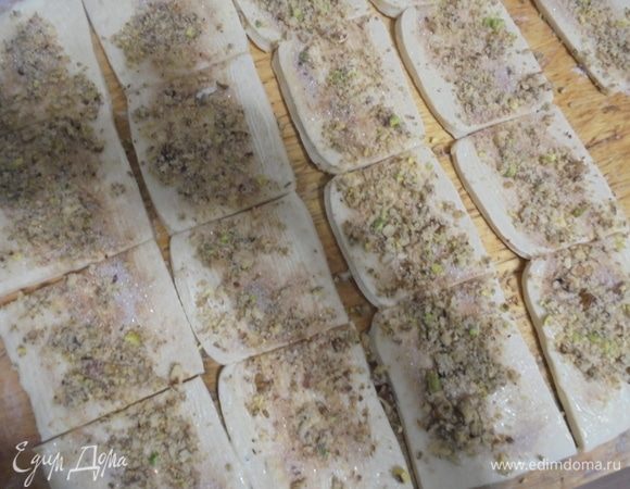 Посыпать полоски ореховой смесью и разрезать на квадратики размером примерно 5 на 5 см.