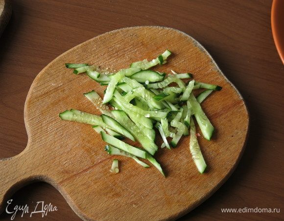 Нарезаем соломкой огурец, совсем немного, 1/4 от целого, и белую часть крабовой палочки.