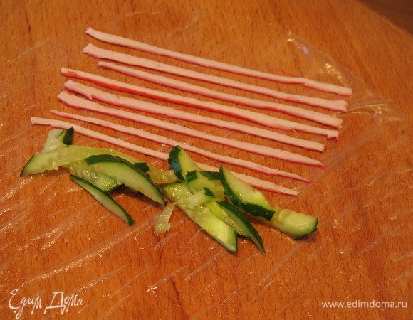 Под полосками кладем огурцы.