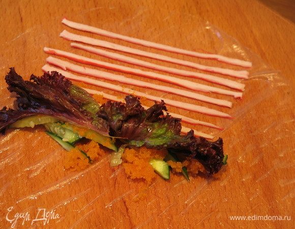 На них салат и чайную ложку икры, распределяя по длине.