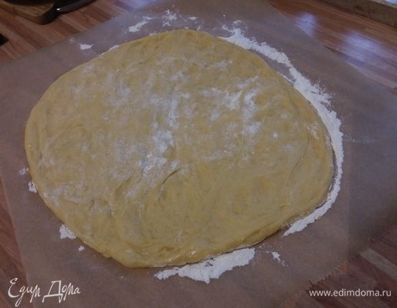 Лист пергаментной бумаги присыпать мукой, выложить тесто. Оно мягкое и нежное. Распластать тесто в круг. Я делала ладошки, предварительно притрусив поверхность мукой. 