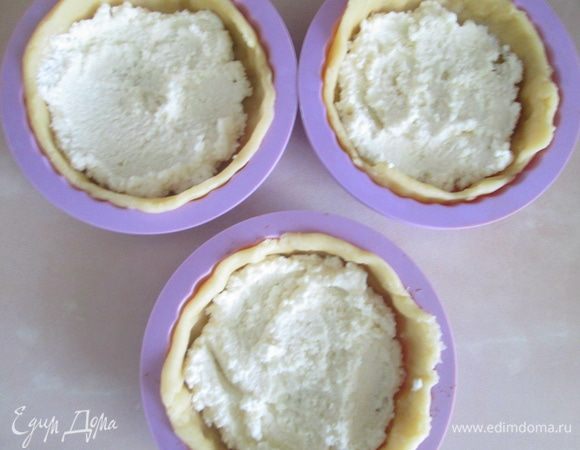 Первым слоем на тесто выложить творожную массу.