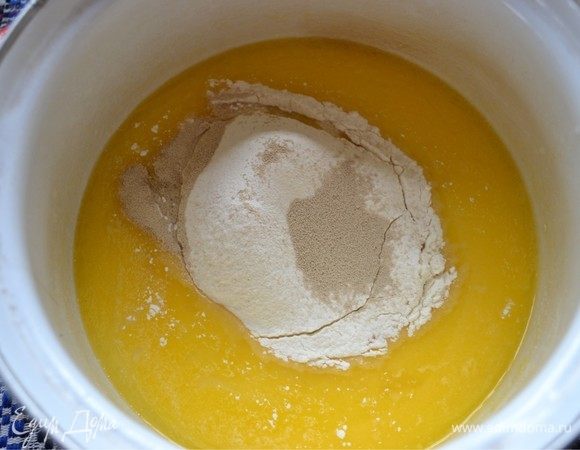 Далее добавляем к смеси просеянную муку и сухие дрожжи. Внимательно и постепенно добавляйте муку, замешивая тесто. Оно должно быть правильной консистенции. 