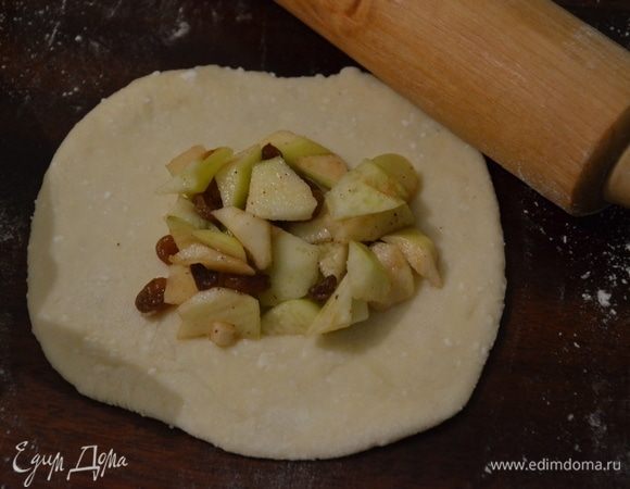 Тесто делим на небольшие кусочки, раскатываем кусочек теста в лепешку 4-5 мм толщиной, в серединку выкладываем начинку. Поднимаем края лепешки к центру, защипываем и формируем круглый пирожок.