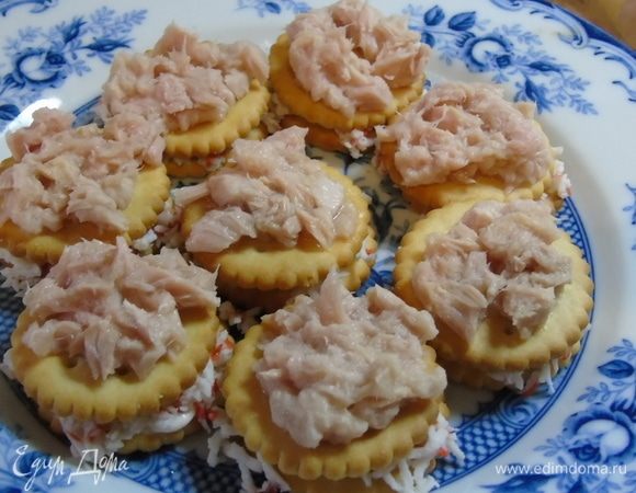 Накройте крекером и выложите ложкой тунец.