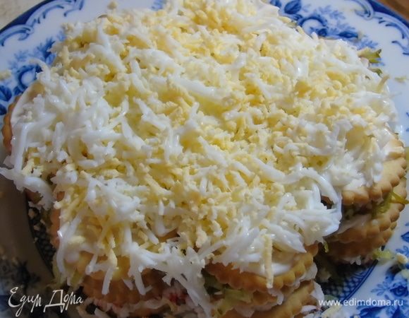 Слой крекера смазанного майонезом. Посыпаем тертыми отваренными заранее яйцами.