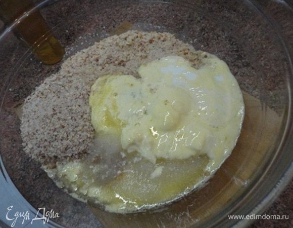 Добавить измельченный миндаль, растопленное сливочное масло, сахар и лимончелло. Перемешать. Дно разъемной формы застелить пекарской бумагой, бока смазать маслом или также использовать пекарскую бумагу. Полученную массу выложить на дно формы.