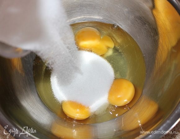 В отдельную посуду вбить 3 яйца, всыпать 1 стакан сахара. Хорошо перемешать венчиком, но не взбивать. 