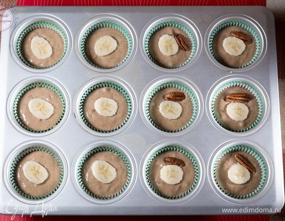 Выложить в формочки тесто, заполняя их не до конца примерно на 2/3 или 3/4 если нравятся высокие маффины. Украсим наши маффины оставшейся половинкой банана, нарезав кружочками. Также можно украсить орехами.