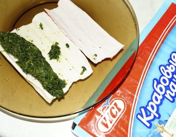 Шпинат выложить на край крабовой палочки.