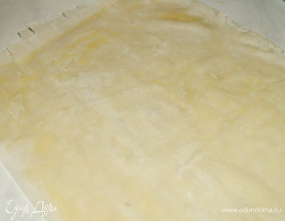 Тесто фило разделить на листы. Смазать один лист растопленным сливочным маслом, сложить пополам, затем снова смазать маслом и сложить вдвое.