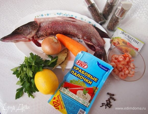 Подготовьте необходимые продукты. Рыбу отделить от костей и головы, подготовить филе с кожей. 
Морковь отварить. Крабовые палочки разрезать на 2-3 части. Лимон нарезать на тоненькие полукружочки.