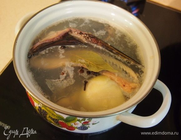 Сварить рыбный бульон из головы и хребта рыбы, вместе с головкой лука, гвоздикой и душистым перцем, 30-40 мин. на самом слабом огне. Бульон должен не бурлить, а слегка «колыхаться», тогда он будет прозрачным, а не мутным. Готовый рыбный бульон остудить и процедить через марлю.