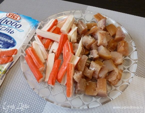 Белую рыбу и крабовые палочки нарежем кусочками.