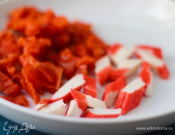 Тем временем порежьте половину копченого лосося и отставьте — он пойдет в крем, как добавка в виде кусочков. Оставшегося лосося нарезать произвольно, добавить нарезанные крабовые палочки Vici.