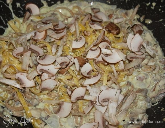 Аккуратно перемешиваем, добавляем почти сразу вторую часть грибов, порезанную ломтиками. Перемешиваем снова. Важно перемешивать аккуратно, что бы феттучине не сломались/не порвались. Я перемешивала, подкидывая ее на сковороде, и иногда помогала специальной шумовкой для пасты с зубчиками.