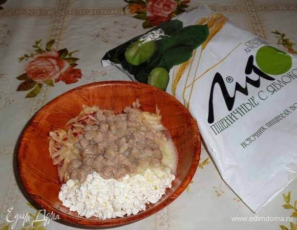 В чашку выкладываем творог, натертое яблоко, набухшие отруби. Добавляем слегка взбитое яйцо. 