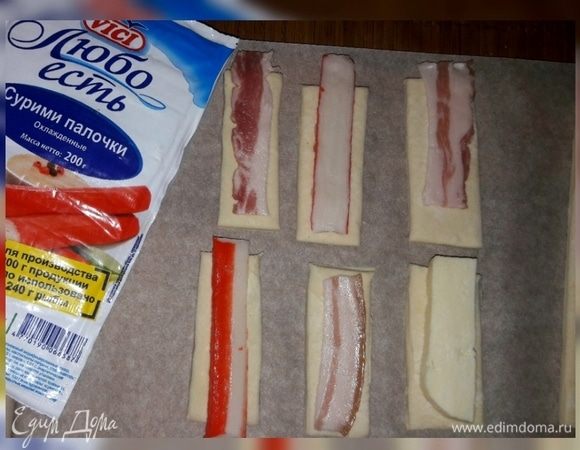 На тесто выложить крабовые палочки, бекон, сыр. 