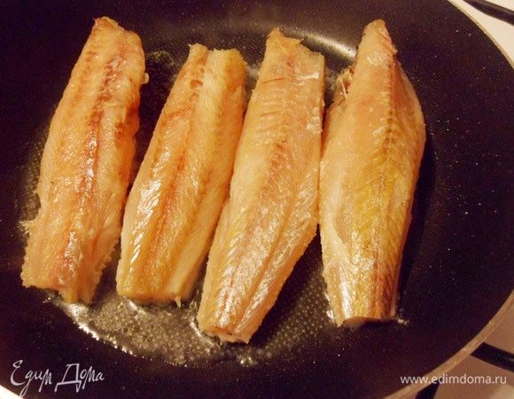 Влить на разогретую сковороду ложку растительного масла и выложить тушки хека.