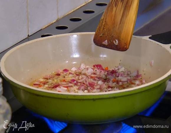 Разогреть в сковороде 2 ст. ложки оливкового масла, выложить лук, чили и чеснок, посыпать орегано, слегка посолить, поперчить и обжарить.