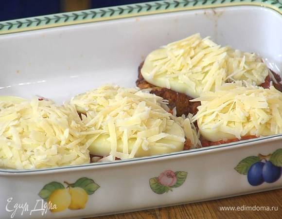 Обжаренные отбивные выложить в жаропрочную керамическую форму, залить соусом, сверху разложить моцареллу, посыпать все натертым сыром.