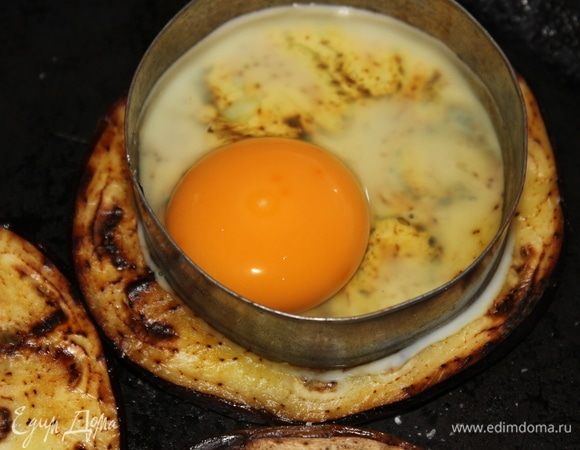 На каждый готовый ломтик баклажана выложить металлическую форму, и вбить в нее аккуратно яйцо. В идеале, иметь 3 или более одинаковые формы, чтобы готовить все сразу. Но у меня в наборе все формы разного размера, поэтому я выбрала одну подходящего и готовила по одному.