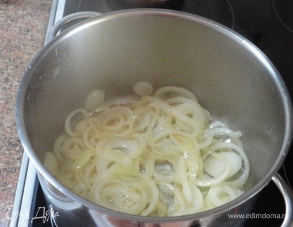 Все овощи, за исключением лука, нарезать примерно одинаковыми кубиками, чеснок мелко порубить. Лук нарезать кольцами. В большой кастрюле с толстым дном нагреть сливочное и растительное масло, и обжарить лук до светло-золотистого цвета.