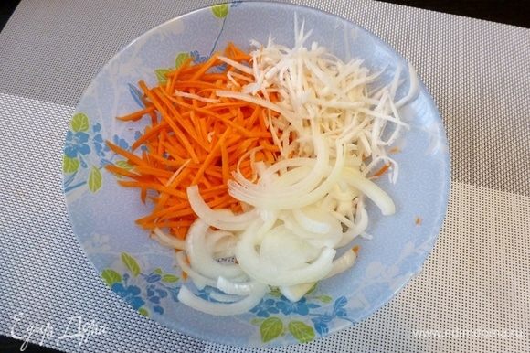 На терке для корейских салатов натрем морковь среднего размера, редьку. Половину луковицы нарежем полукольцами. Редьку лучше взять сладкую и сочную. Если она слишком острая, то ее лучше вымочить в холодной воде. Иначе она забьет вкус салата своей резкостью.