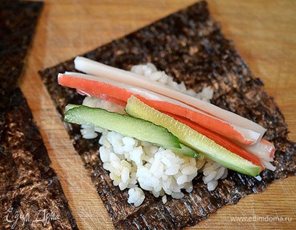 Сверху — крабовые палочки и огурец.