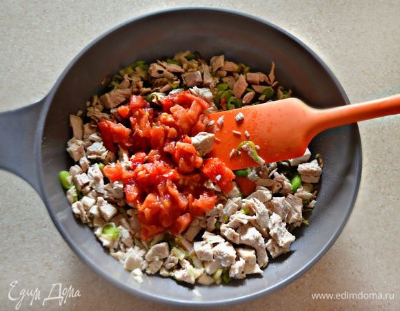 Помидор освободите от шкурки, мелко порубите и добавьте вместе с мясом к луку. Потушите всё вместе 5–7 мин, периодически помешивая. Приправьте солью и перцем.