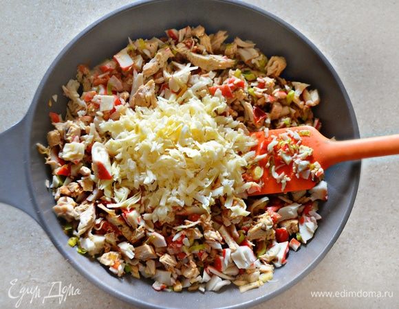 Добавьте крабовое мясо и тертый сыр (любой, ваш любимый твердый сыр) в начинку и перемешайте.