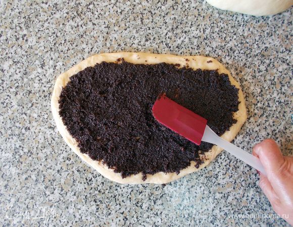 С помощью силиконовой лопатки (или ножа, ложки) равномерно  размазываем начинку по тесту. Сворачиваем рулет, плотно прижимая тесто.