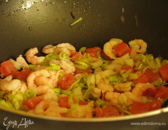 Кладем семгу и креветки к луку.